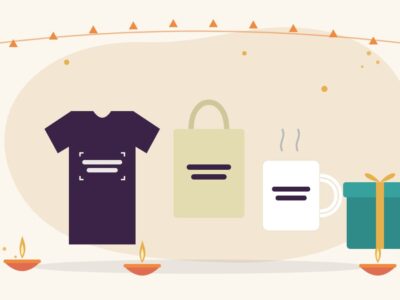 Illustration of a festive Diwali gift table with a folded t-shirt, a cotton tote bag, a mug, a wrapped gift box and glowing diyas, for Diwali gifts that give back